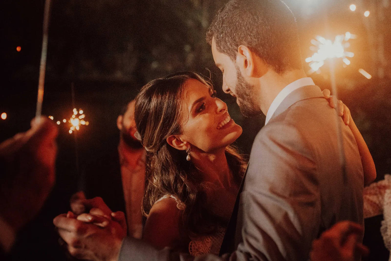 Casal em momento de conexão próxima, cercado por luzes de estrelinhas.