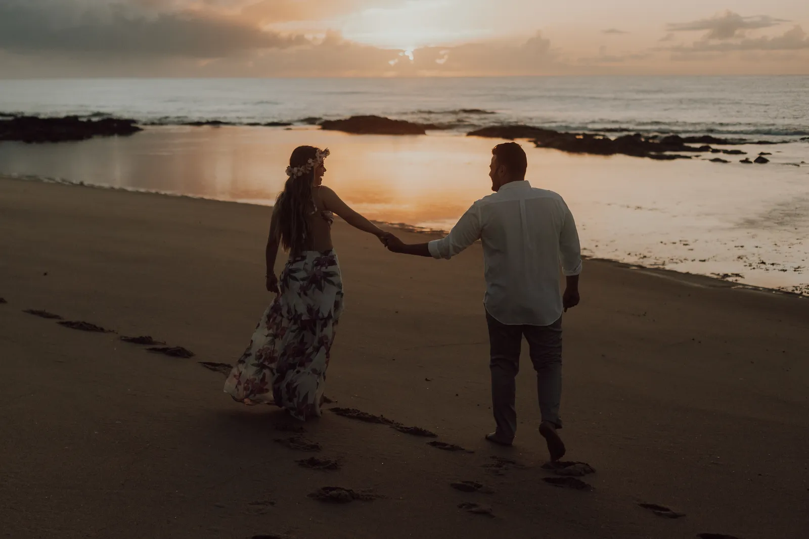 O casal caminhando em direção à orla, sugerindo continuidade.