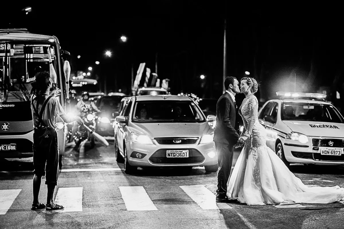 O casal em meio ao trânsito urbano, em preto e branco.
